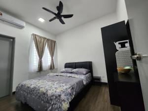 een slaapkamer met een bed en een plafondventilator bij Bunga Rampai Homestay, Vista Bangi in Bangi