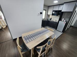 a kitchen with a wooden table and chairs at Bunga Rampai Homestay, Vista Bangi in Bangi