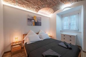 een slaapkamer met een bed en een bakstenen muur bij [Quadrilatero Loft] Elegant Stay in Turijn