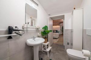 een witte badkamer met een wastafel en een toilet bij [Quadrilatero Loft] Elegant Stay in Turijn