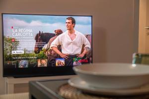 een tv scherm met een man voor bij [Quadrilatero Loft] Elegant Stay in Turijn