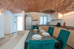 een eetkamer met een tafel en groene stoelen bij [Quadrilatero Loft] Elegant Stay in Turijn