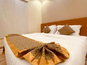 اجنحة الواحة  في المدينة المنورة: غرفة نوم فيها سرير عليه شراشف بيضاء و ثوب ذهبي