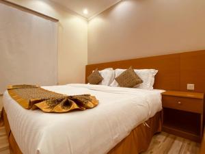اجنحة الواحة  في المدينة المنورة: غرفة نوم مع سرير أبيض كبير مع اللوح الأمامي الخشبي