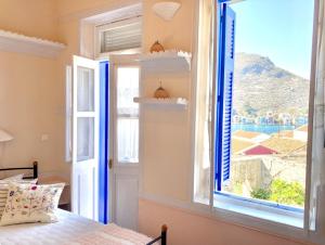 a bedroom with a window with a view of the ocean at Chroma Kastellorizo in Meyisti