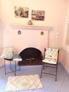 a living room with a fireplace and a chair at Chroma Kastellorizo in Meyisti