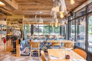 un restaurant avec des tables, des chaises et des fenêtres dans l'établissement Armancette Hôtel, Chalets & Spa – The Leading Hotels of the World, à Saint-Gervais-les-Bains