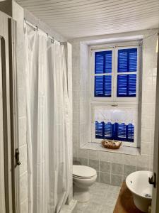 a white bathroom with a toilet and a window at Chroma Kastellorizo in Meyisti