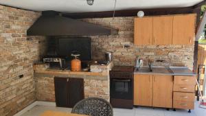 uma cozinha com um fogão e uma parede de tijolos em Holiday home with private pool ''Lux Banja Luka'' em Banja Luka