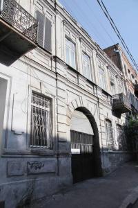 un antiguo edificio con un arco en una calle en Angels Roof Vera - boutique apartment. Wine Factory, en Tiflis