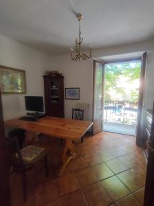 uma sala de jantar com uma mesa de madeira e uma porta de vidro deslizante em Casa Valda em Fanano