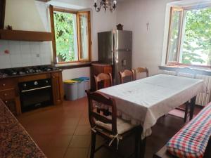 a kitchen with a table and a refrigerator at Casa Valda in Fanano