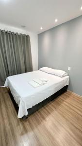 een slaapkamer met een groot bed met witte lakens bij Moov 2517 Studio Mooca in Sao Paulo