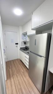 een keuken met witte kasten en een koelkast bij Moov 2517 Studio Mooca in Sao Paulo