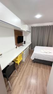 een slaapkamer met een bed en een bureau en een bed en een bureau bij Moov 2517 Studio Mooca in Sao Paulo
