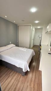 een slaapkamer met een groot bed en een houten vloer bij Moov 2517 Studio Mooca in Sao Paulo