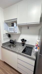 een keuken met witte kasten en een aanrecht bij Moov 2517 Studio Mooca in Sao Paulo