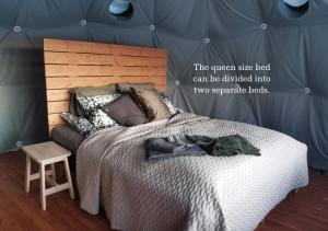 a bedroom with a large bed with a wooden headboard at Arctic Nature Experience Glamping in Vuontisjärvi +11 photos