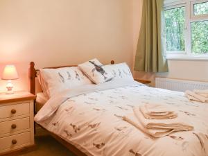 a bedroom with a bed and a window at Woodlander in Dorchester