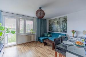 ein Wohnzimmer mit einem blauen Sofa und einem Tisch in der Unterkunft Pet’s House Warsaw in Warschau