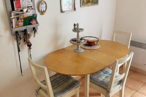 een eettafel met 2 stoelen en een kom erop bij Charmante maison douillette de 65 m2 pour 4 pers. in Saint-Pierre-dʼOléron