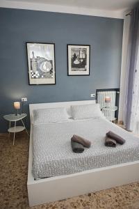 a bedroom with a white bed with a blue wall at B&B Pisaland in Pisa
