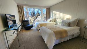 um quarto de hotel com duas camas e uma janela em Hotel Lago Grey em Torres del Paine