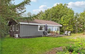 a small house with a patio and a yard at Awesome Home In Roslev With 3 Bedrooms And Wifi in Nøreng