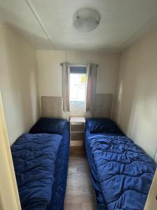 2 camas en una habitación pequeña con ventana en RBR 662 - Beach Resort Kamperland, en Kamperland