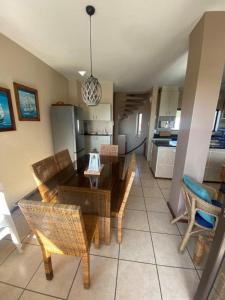 a living room with a table and chairs and a kitchen at Umdloti Cabanas 32 Triplex in Umdloti