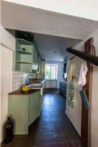 a kitchen with green cabinets and a sink at Rooms in the center of Ystad in Ystad