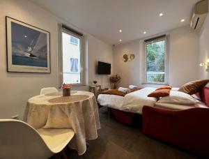 a bedroom with two beds and a table and a couch at Appartement - Cannes vieille ville - Le Suquet in Cannes