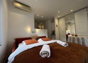 - une chambre avec un grand lit et des serviettes dans l'établissement Appartement - Cannes vieille ville - Le Suquet, à Cannes