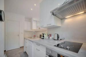 a kitchen with white cabinets and a stove top oven at Appartement - Cannes vieille ville - Le Suquet in Cannes +12 photos