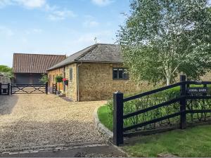 a house with a fence in front of it at The View in West Stow