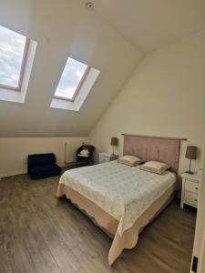 een slaapkamer met een bed en 2 ramen bij Duplex lumineux Saint Ouen sur Seine in Saint-Ouen
