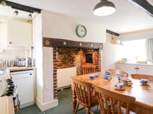 uma cozinha e sala de jantar com mesa e cadeiras em Lower Farm Cottage em Weymouth