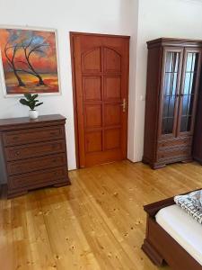 a bedroom with a wooden door and a wooden floor at Rege apartman 3 in Alsóörs