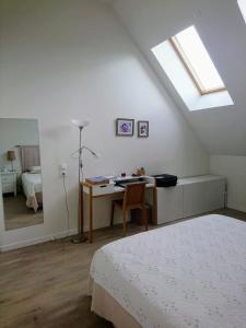 een slaapkamer met een bed, een bureau en een raam bij Duplex lumineux Saint Ouen sur Seine in Saint-Ouen