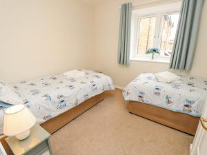een slaapkamer met 2 bedden en een raam bij Harbour View Poole in Poole