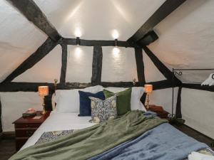 a bedroom with a large bed in a room with beams at Avonmede in Tewkesbury