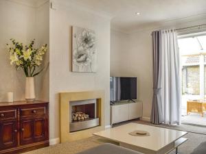 a living room with a fireplace and a tv at Kennet Valley View in Tilehurst