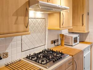 a kitchen with a stove and a microwave at Kennet Valley View in Tilehurst
