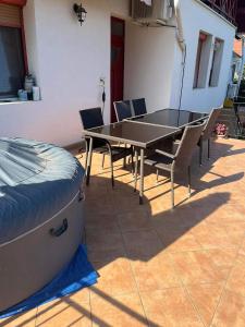 a ping pong table and chairs on a patio at Rege apartman 3 in Alsóörs