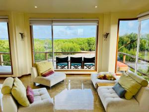 a living room with two couches and a large window at Blue Heron Galápagos Villa in Puerto Ayora