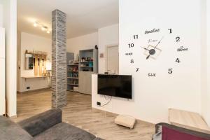 un soggiorno con un grande orologio sul muro di Parco Paradiso & MM Marche Family Apartment a Torino