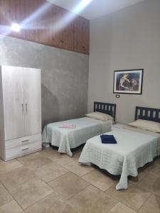 Zimmer mit 2 Betten und einem Schrank in der Unterkunft Nature House Federico in Bernalda