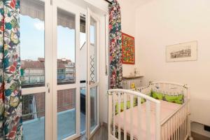 una culla in una stanza con finestra di Parco Paradiso & MM Marche Family Apartment a Torino