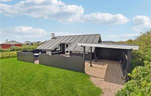 a house with a black roof and a fence at Beautiful Home In Harbore With Wifi in Harboør