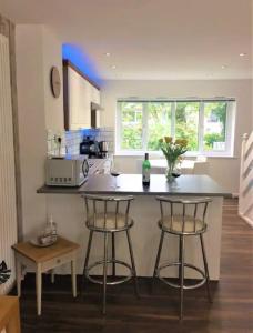 a kitchen with two bar stools and a counter at Springer Villa, 2 bed, Newquay in Newquay